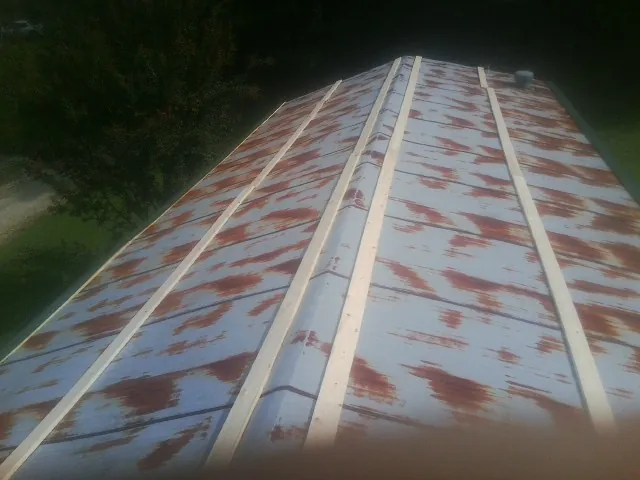 Rusted metal roof panels with new wood purlins before replacement — Storm Damage Roof Repair in Arona by Roofing Brothers