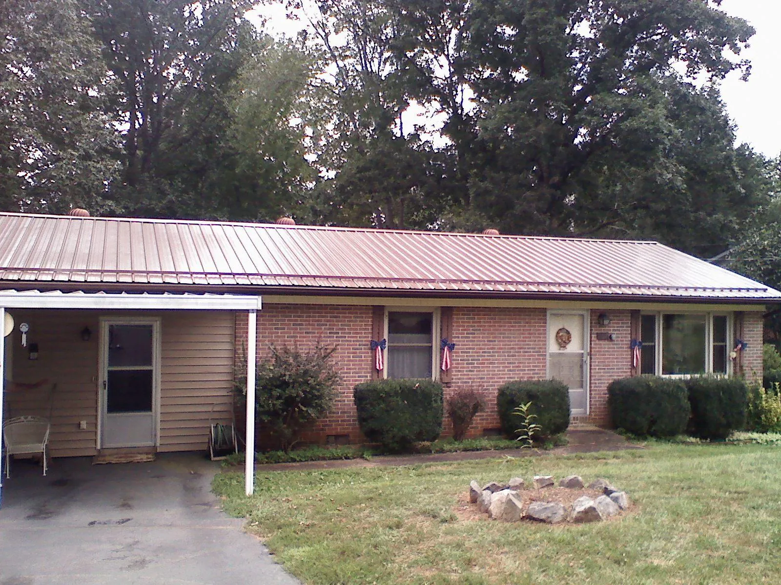 Bronze metal roof and carport on a brick ranch home — Roof Repair work by our crew in Arona