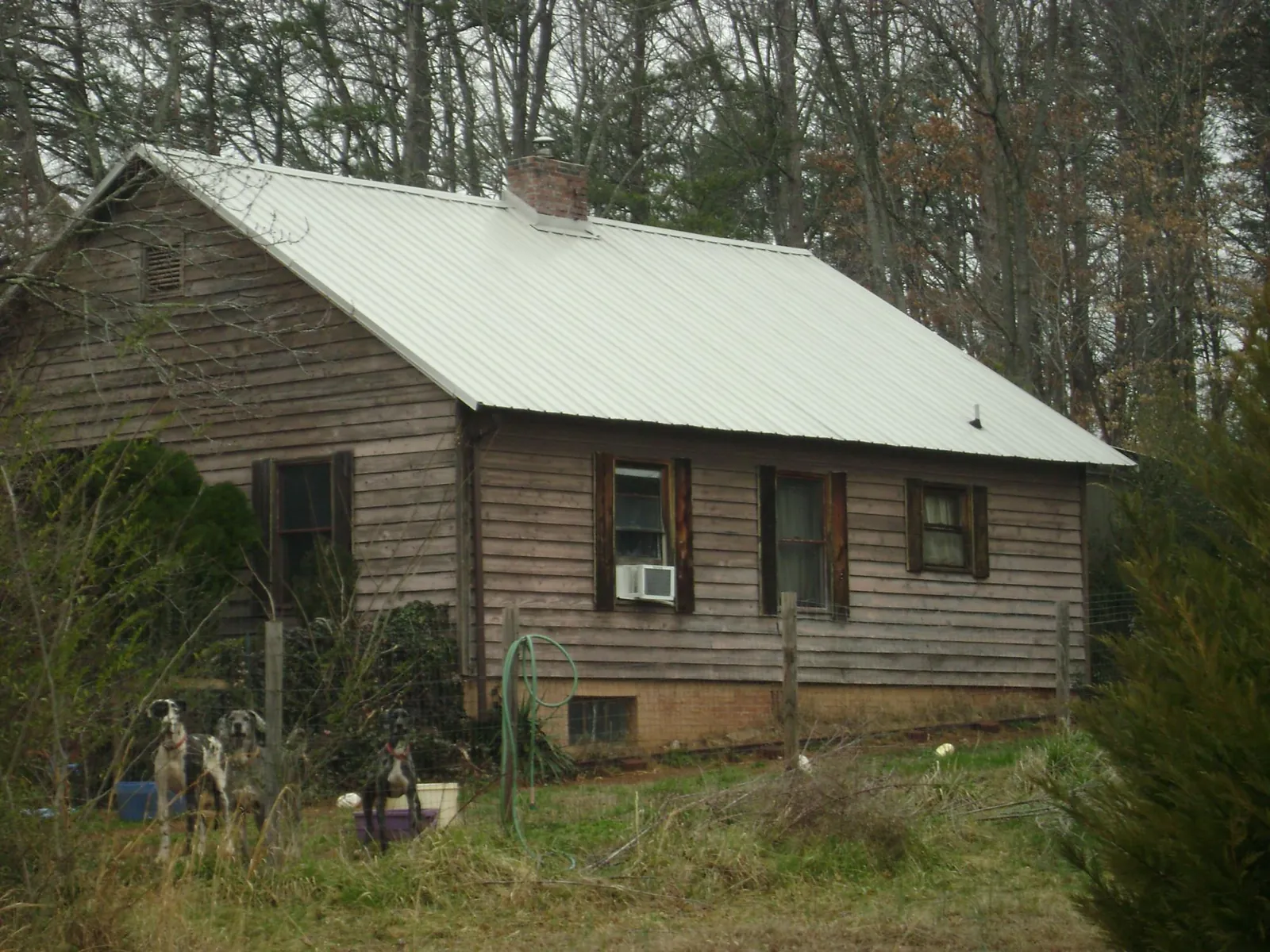 White metal roof on an old wood sided farmhouse, from a Metal Roof Installation job in Arona